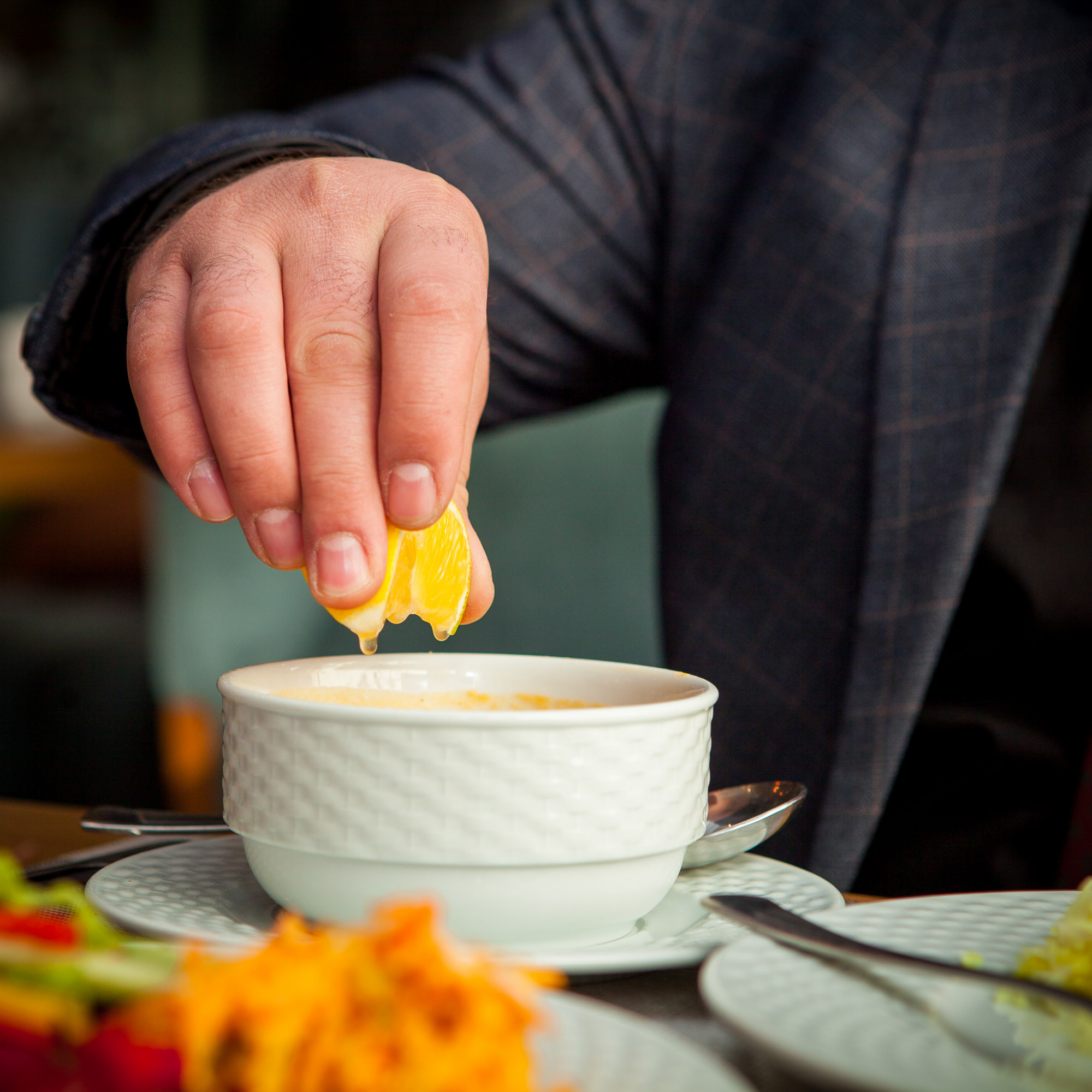 Chef tasting sauce in small bowl